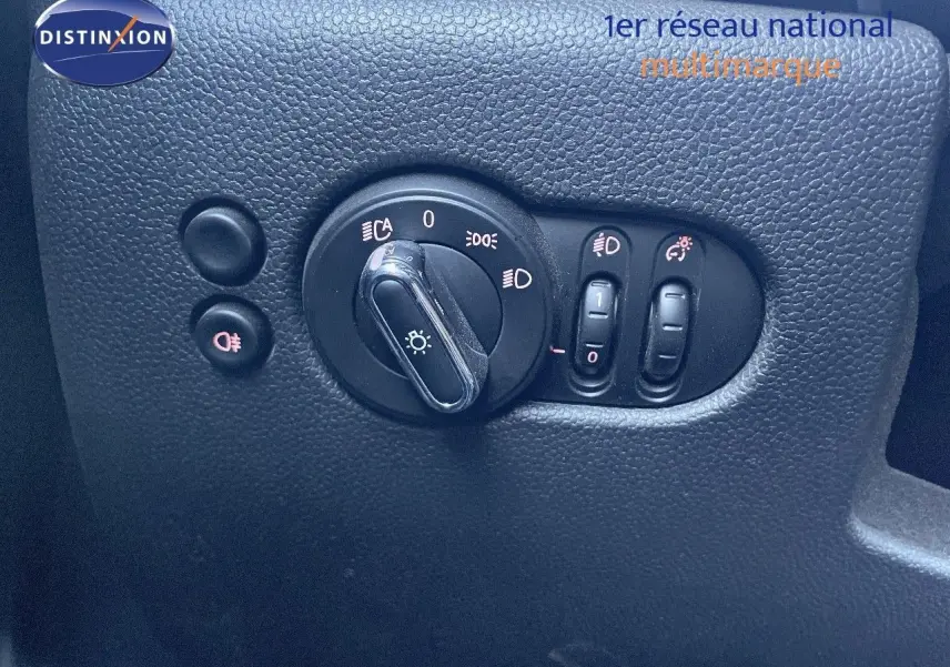 Gros plan sur les commandes d'éclairage du tableau de bord d'une MINI Cabriolet F57 noire, avec interrupteurs et réglages visibles.