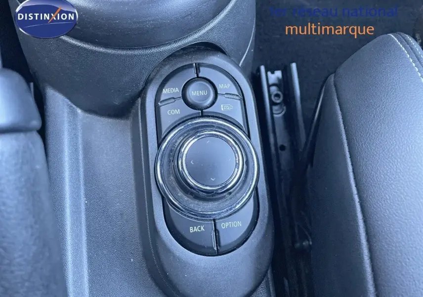 Gros plan sur la molette de commande multimédia au centre de la console d'une MINI Cabriolet noire.