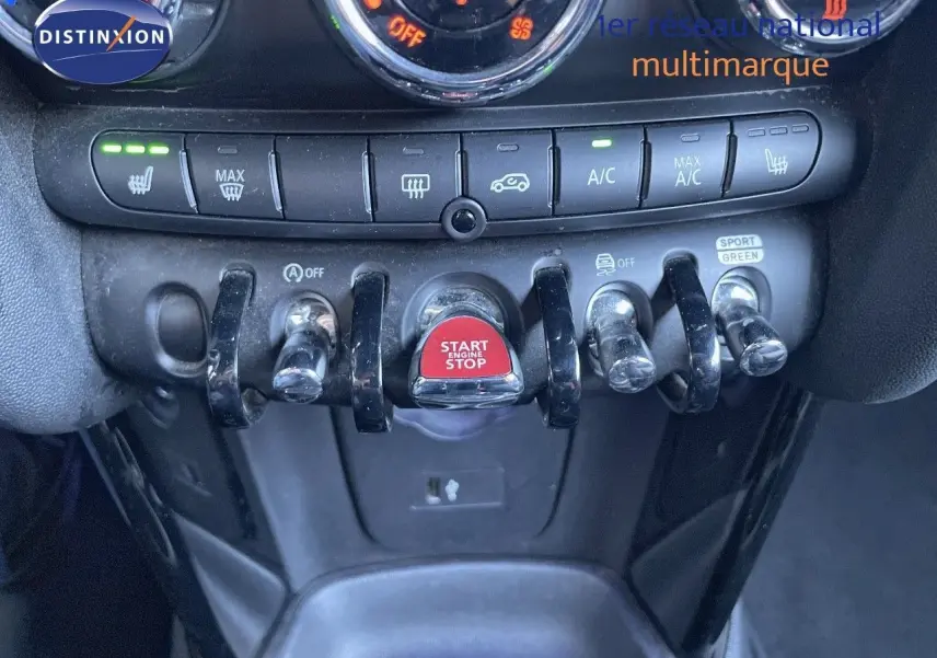Gros plan sur la console centrale du MINI Cabriolet noir avec boutons de climatisation et bouton rouge Start/Stop.