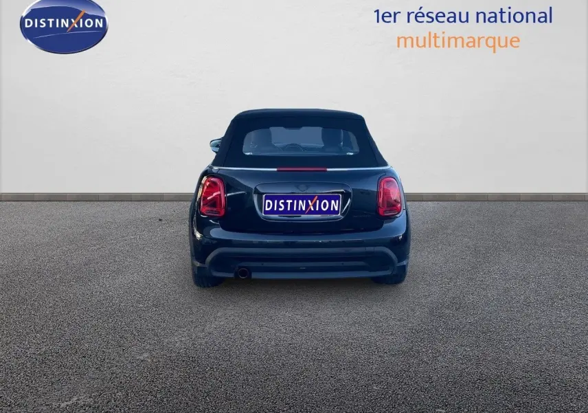 Vue arrière d'une MINI Cabriolet F57 noire Midnight Metal avec capote fermée, sur fond neutre et logo Distinxion.