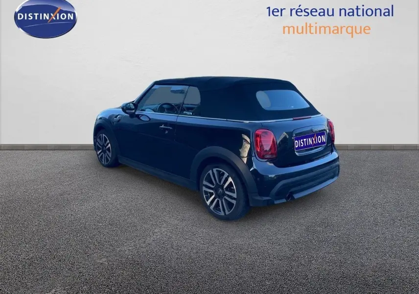 Vue 3/4 arrière droite d'une MINI Cabriolet F57 noire Midnight Metal avec toit fermé sur fond neutre.