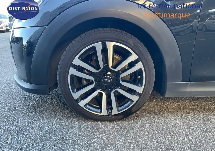 Gros plan sur la roue avant gauche d'une MINI Cabriolet F57 noire Midnight Metal avec jante alu bi-ton 17 pouces.