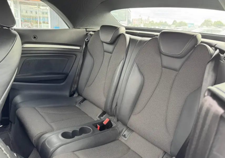 Vue intérieure arrière des sièges en tissu et cuir gris foncé de l'Audi A3 Cabriolet S Line 2019 avec accoudoir central et ceintures de sécurité.