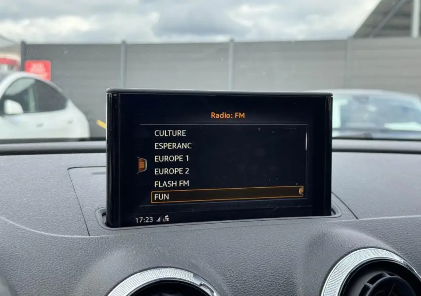 Écran central du système multimédia de l'Audi A3 Cabriolet 2019 affichant les stations radio FM, intérieur gris.