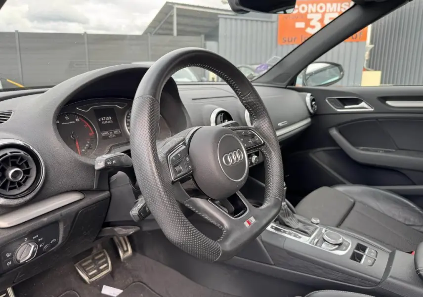 Intérieur noir de l'Audi A3 Cabriolet 2019, vue côté conducteur sur le volant sport multifonction et tableau de bord.