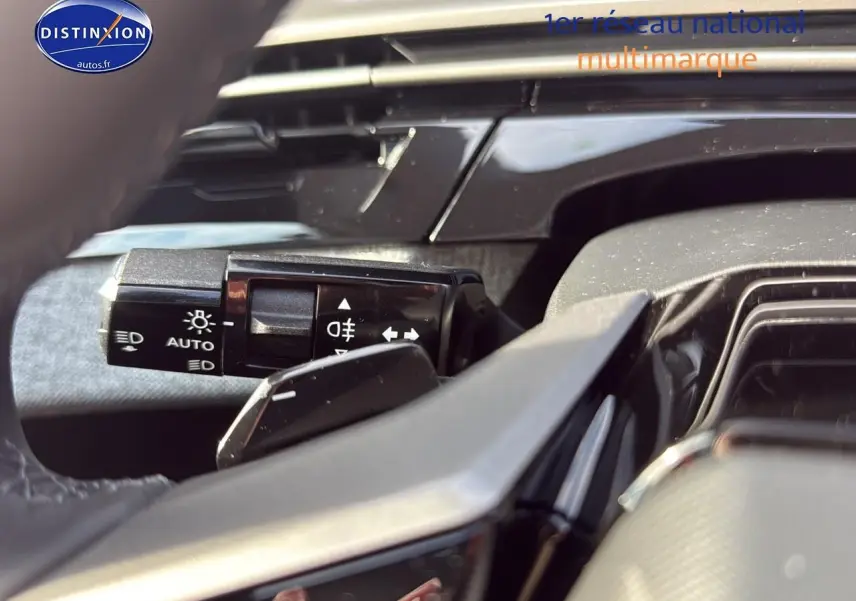 Gros plan sur la manette de commande des phares et clignotants dans l'habitacle du Peugeot 3008 gris titane.