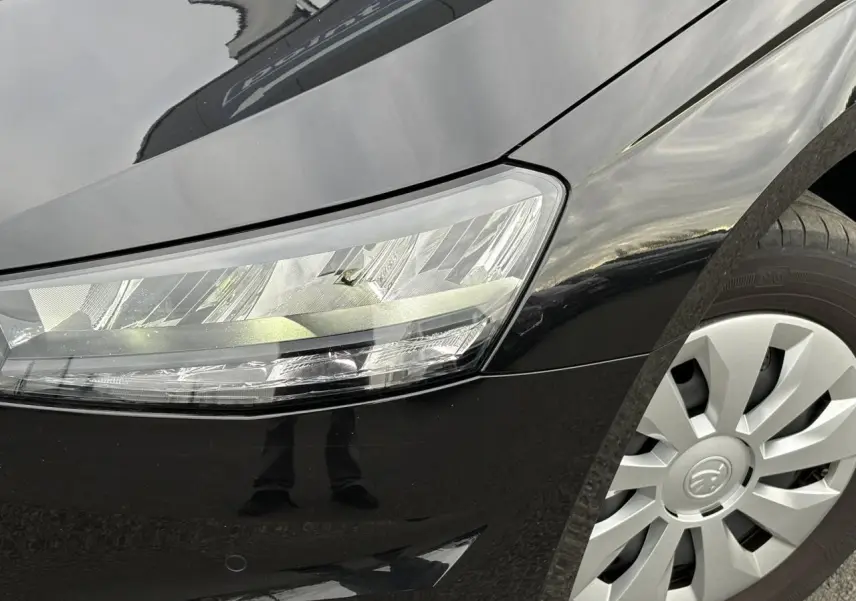 Intérieur avant droit de la SKODA FABIA 2024 noir Magic, sièges tissu gris et console avec boîte manuelle visible.