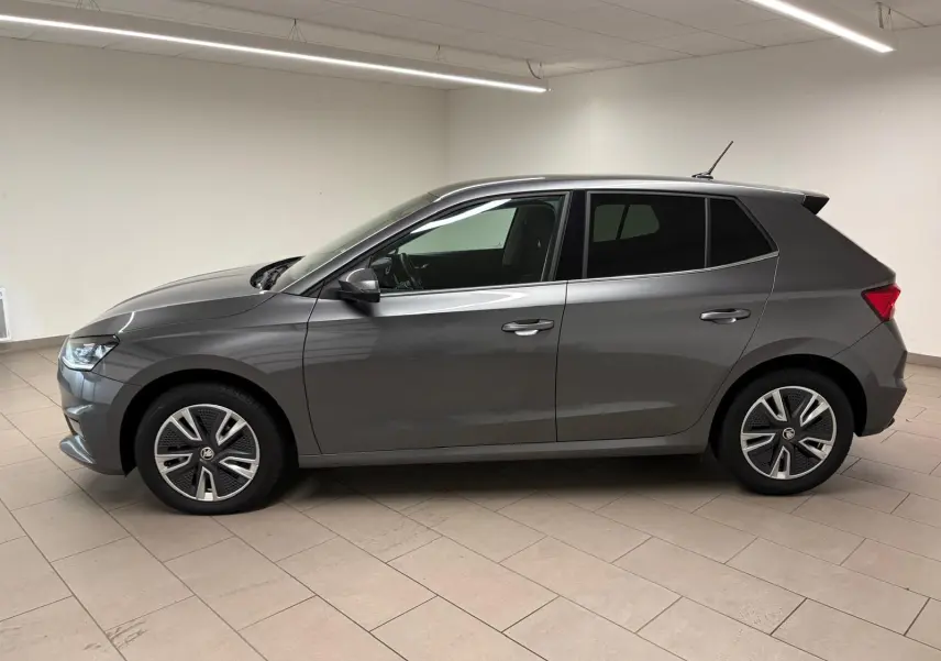 Profil côté gauche de la Skoda Fabia 1.0 TSI 95 BVM5 Style 2023 en gris graphite métallisé dans un intérieur neutre.