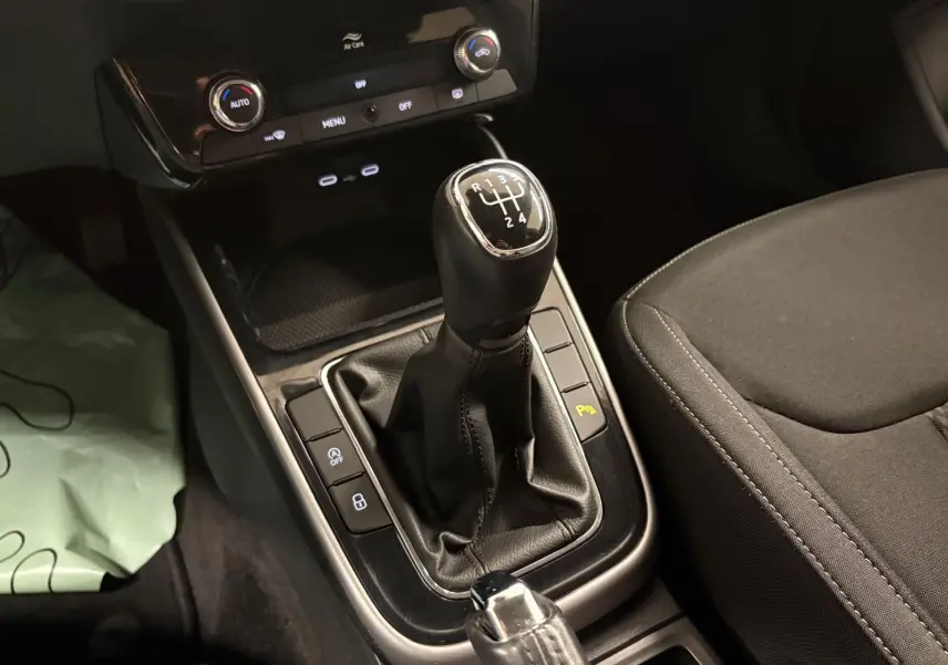 Gros plan sur la commande de la boîte manuelle et la console centrale de la Skoda Fabia 2023, intérieur noir.