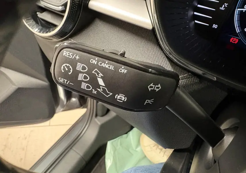 Gros plan sur la commande de régulateur de vitesse à gauche du volant dans l’habitacle d’une Skoda Fabia gris graphite 2023.