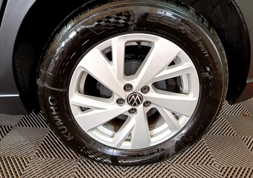 Gros plan sur la roue avant droite du Volkswagen Taigo noir, mettant en valeur la jante alliage et le pneu Kumho.