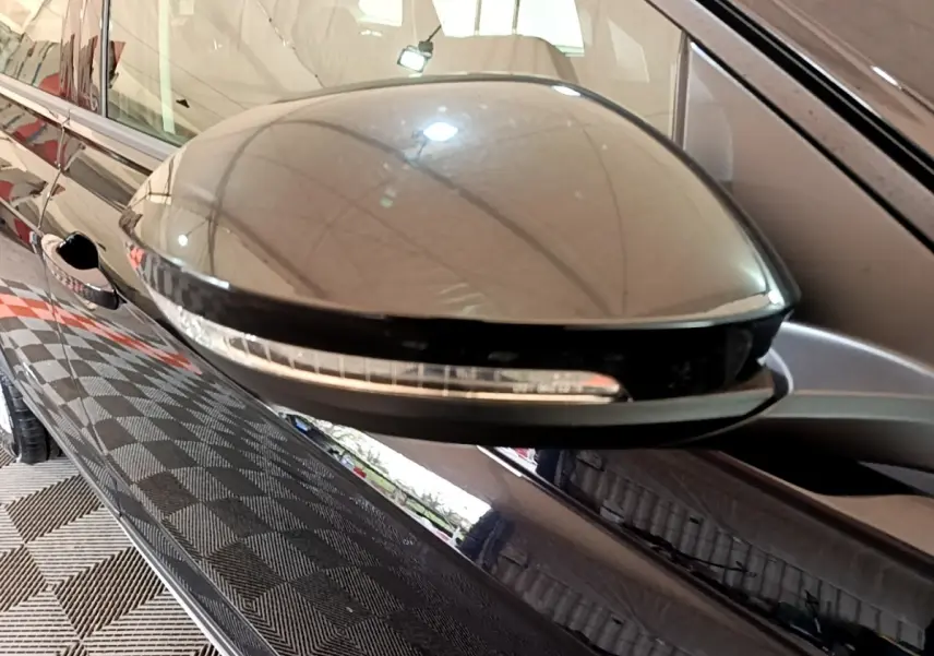 Gros plan sur le rétroviseur droit noir brillant du Volkswagen Taigo 1.0 TSI 95 Life 2023 avec clignotant intégré.