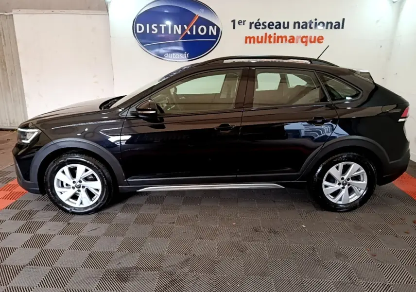 Vue de profil côté gauche d'un Volkswagen Taigo noir 2023 avec jantes alliage et barres de toit noires.
