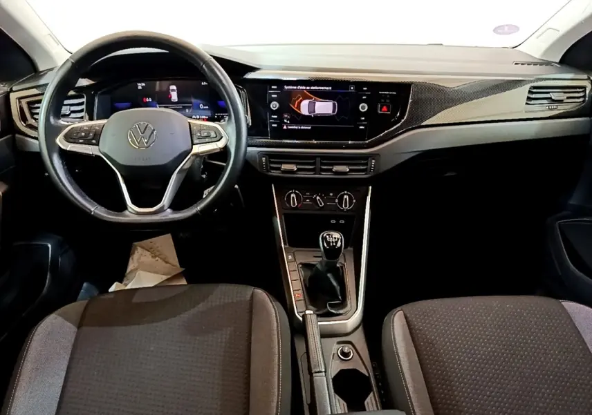 Vue intérieure avant du Volkswagen Taigo 1.0 TSI 95 Life 2023, volant cuir alu, boîte manuelle, tableau de bord digital.