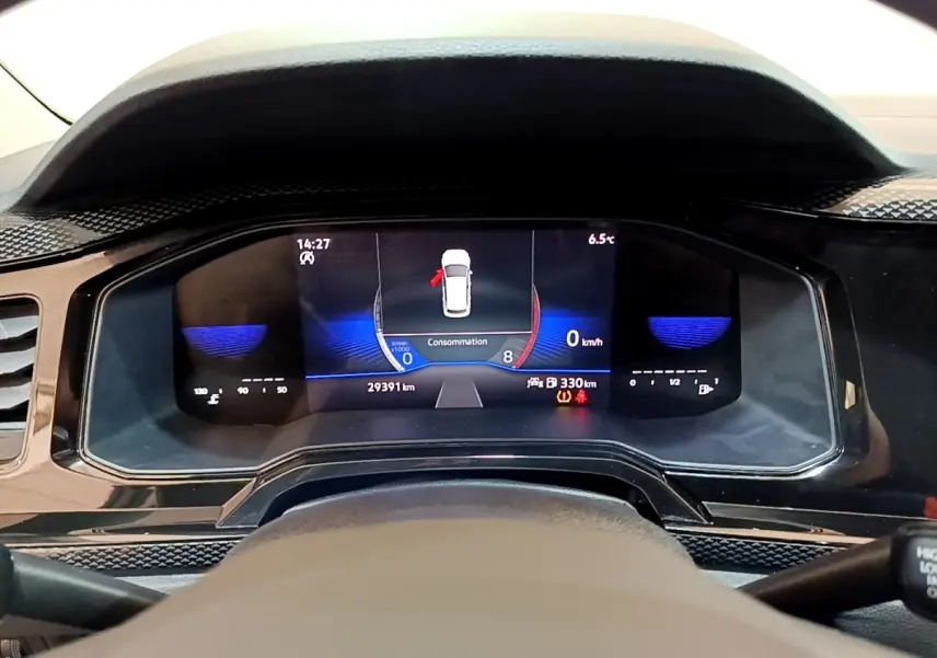 Vue rapprochée du tableau de bord numérique du Volkswagen Taigo noir, affichant la consommation et la vitesse à 0 km/h.