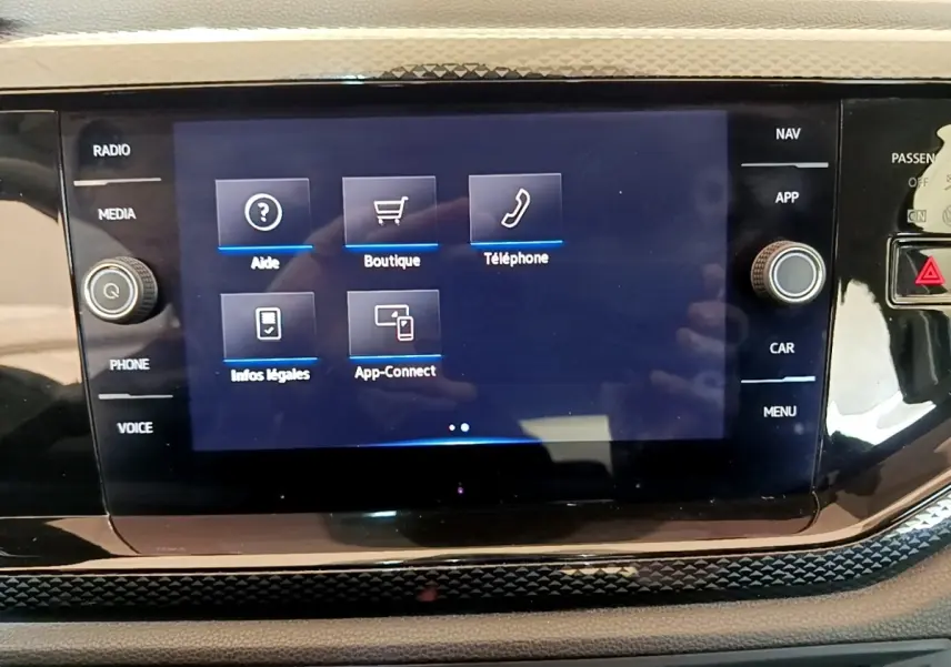 Vue rapprochée de l'écran tactile central du tableau de bord du Volkswagen Taigo noir, affichant les options multimédia.