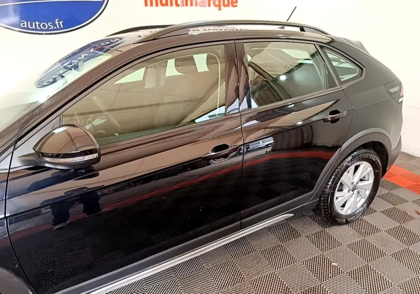 Vue latérale droite du Volkswagen Taigo noir 2023 avec rétroviseurs électriques et jantes alliage visibles.