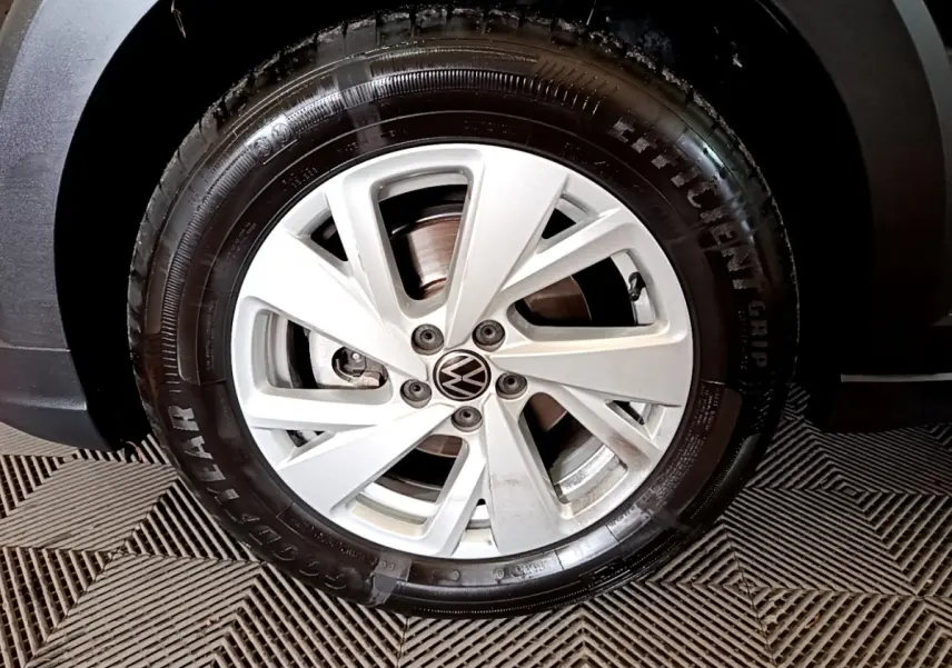 Gros plan sur la roue avant droite avec jante argentée et pneu Goodyear d’un Volkswagen Taigo noir.