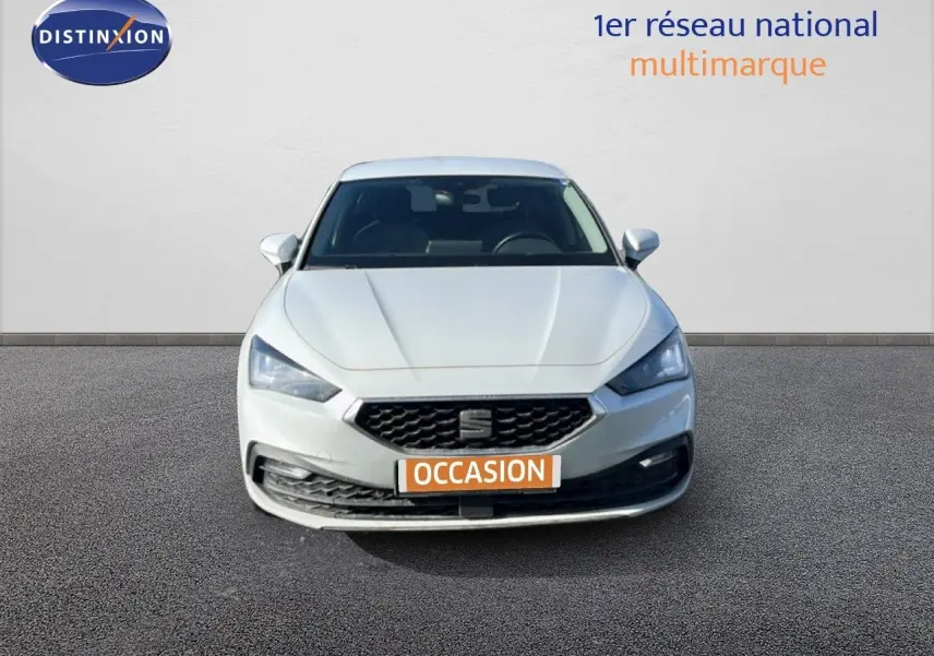 Vue frontale d'une SEAT Leon blanc neige 2025 avec calandre hexagonale et phares LED distinctifs.