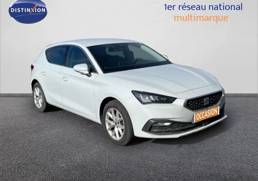 SEAT LEON blanc neige en 3/4 avant droit, mettant en valeur sa calandre noire et ses phares LED distinctifs.
