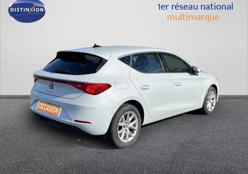 SEAT Leon blanc neige vue 3/4 arrière droit, hayon fermé et vitres teintées sur fond neutre.