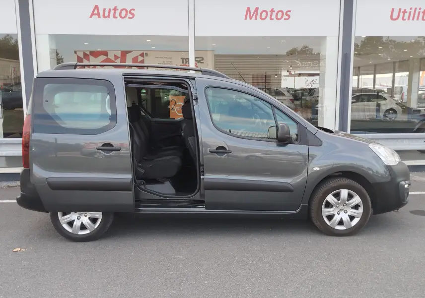 Vue latérale droite d'un Peugeot Partner Tepee gris foncé 2017 avec porte coulissante ouverte, montrant l'intérieur tissu gris.