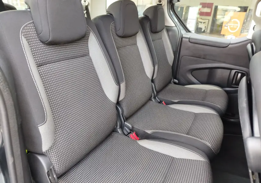 Vue intérieure côté droit montrant les trois sièges arrière en tissu gris foncé du Peugeot Partner Tepee 2017.