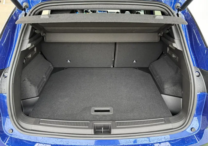 Coffre ouvert vu de l'arrière du Renault Austral bleu Iron Metal, montrant un espace de chargement spacieux et propre.