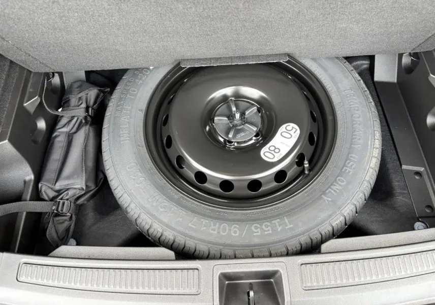 Roue de secours noire en acier dans le coffre du Renault Austral E-Tech Full Hybrid 2025, vue de dessus.