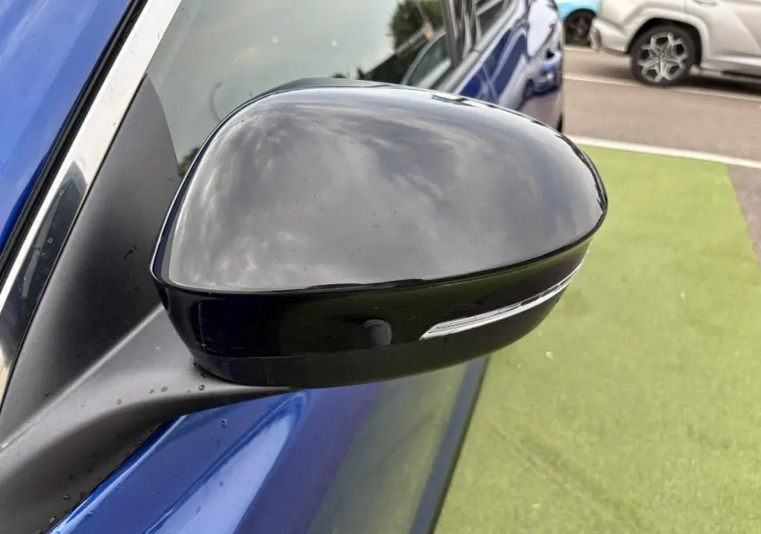 Rétroviseur noir étoilé côté gauche du Renault Austral bleu Iron Metal, avec clignotant intégré visible.