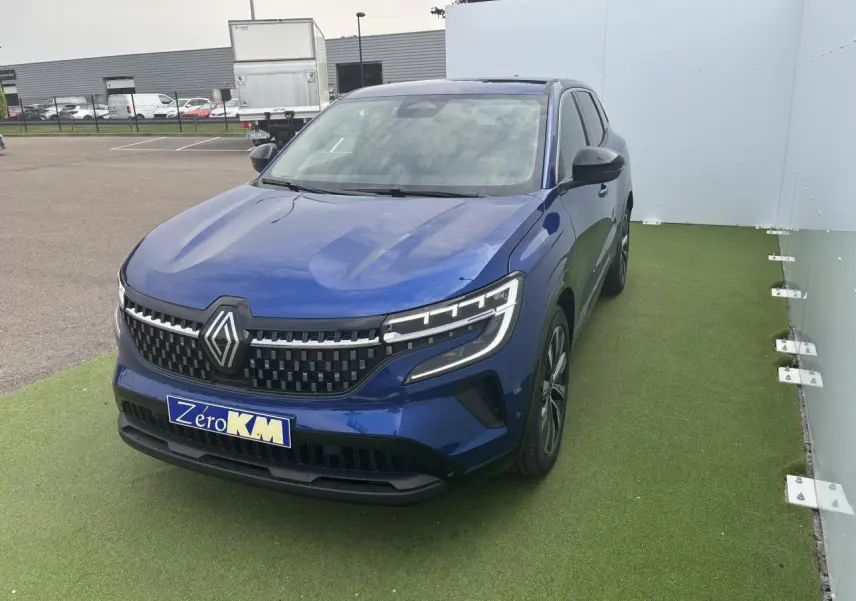 Renault Austral bleu Iron Metal en 3/4 avant droit, avec calandre damier ice black et jantes alliage noires.