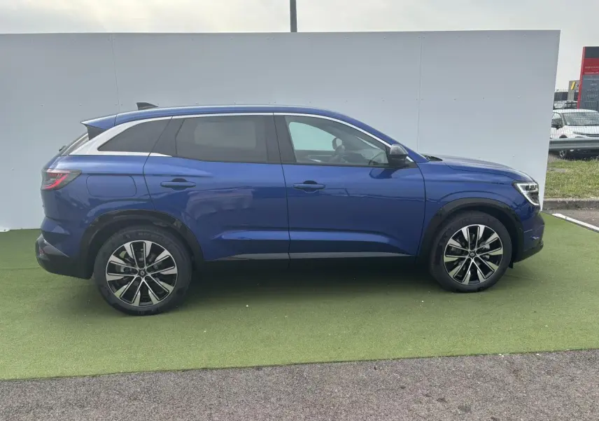 Profil côté droit du Renault Austral bleu Iron Metal 2025 avec jantes alliage noires diamantées et vitres arrière surteintées.