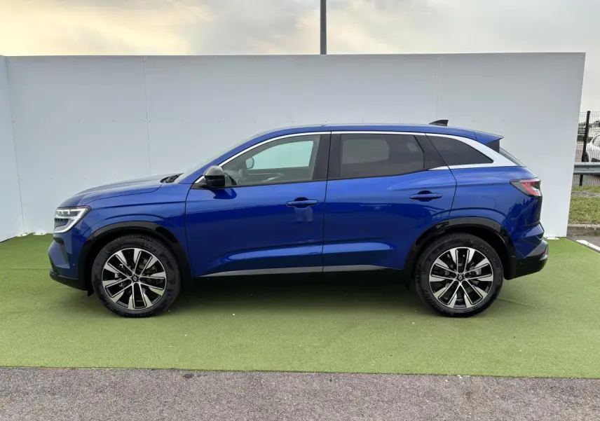 Profil droit du Renault Austral 2025 bleu Iron Metal avec jantes alliage 19 pouces et toit noir étoilé.