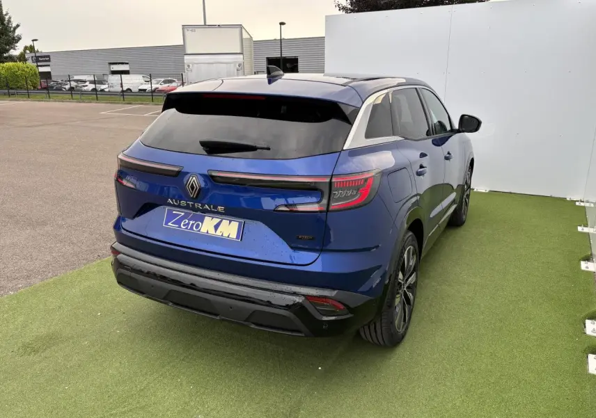 Vue 3/4 arrière droite d'un Renault Austral bleu Iron Metal avec feux arrière LED et hayon motorisé.