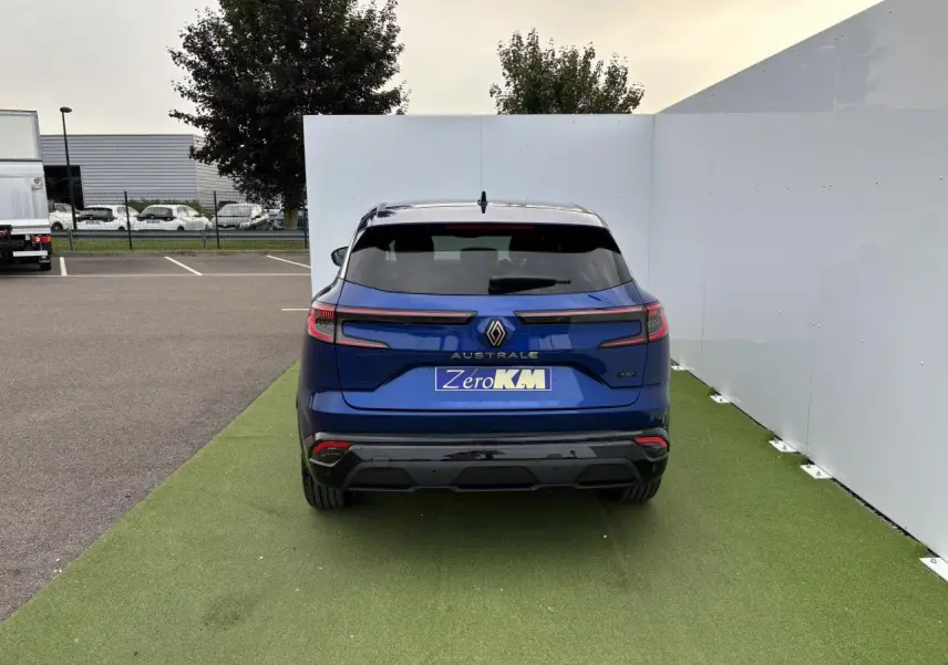Vue arrière du Renault Austral bleu Iron Metal avec hayon motorisé et feux LED adaptatifs sur fond urbain.