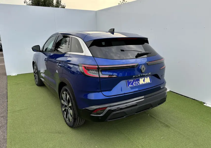 Vue 3/4 arrière droite d'un Renault Austral bleu Iron Metal avec feux arrière LED et jantes alliage noires.