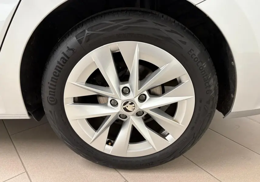 Gros plan sur la roue avant gauche d'une Skoda Octavia Combi gris argent 2023 avec jante alliage à dix branches.