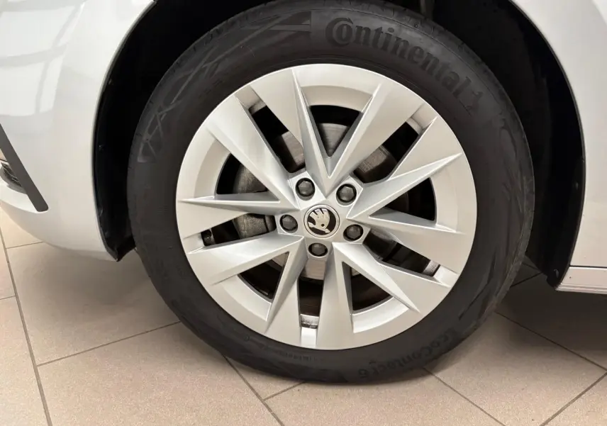 Gros plan sur la roue avant gauche d'une Skoda Octavia Combi gris argent 2023, avec jante alliage et pneu Continental.