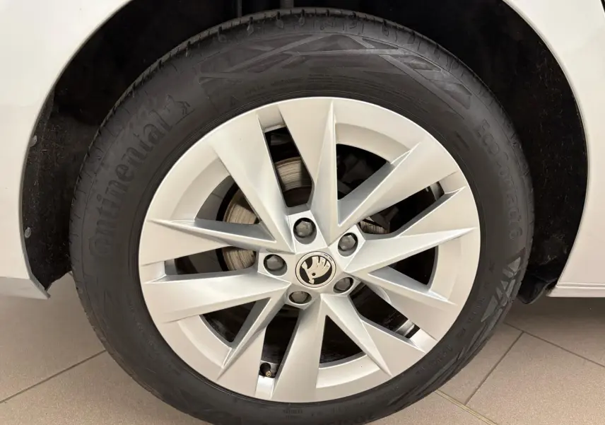 Gros plan sur la roue avant droite de la Skoda Octavia Combi gris argent avec jante alliage à dix branches.