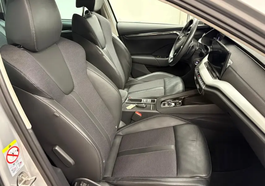 Intérieur avant droit de la Skoda Octavia Combi gris argent 2023, sièges cuir et tissu avec console centrale moderne.