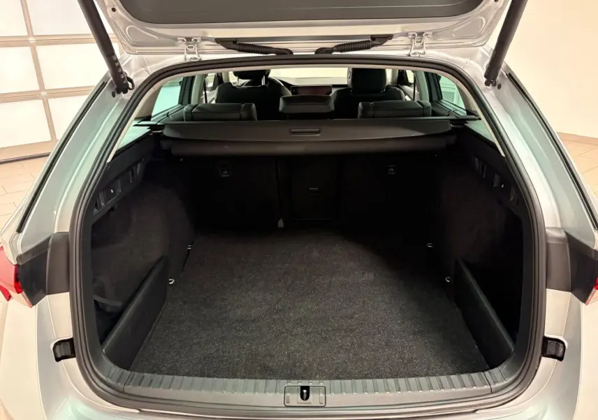 Coffre ouvert vu de l'arrière d'une Skoda Octavia Combi gris argent 2023, montrant l'espace de chargement vide.