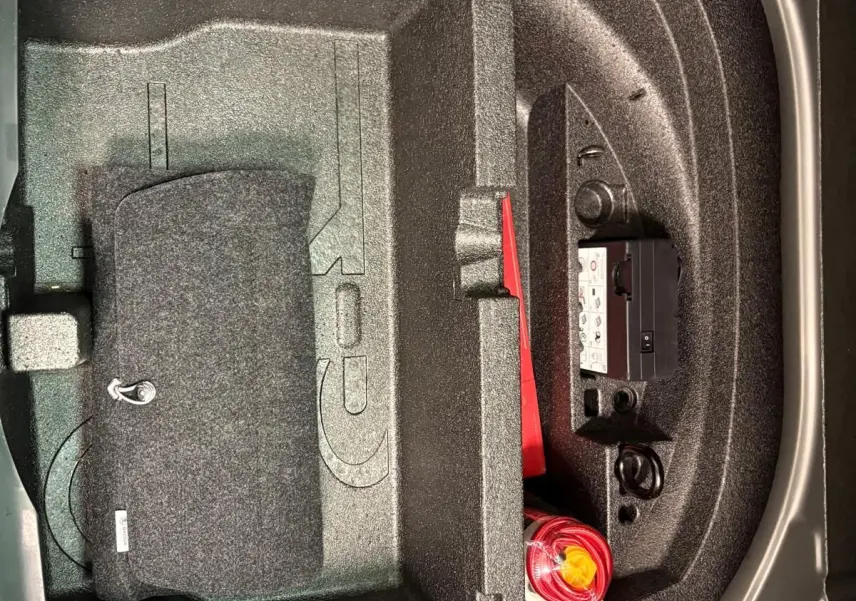 Rangement sous plancher de coffre du Skoda Octavia Combi gris argent 2023, avec kit de sécurité et espace compartimenté.