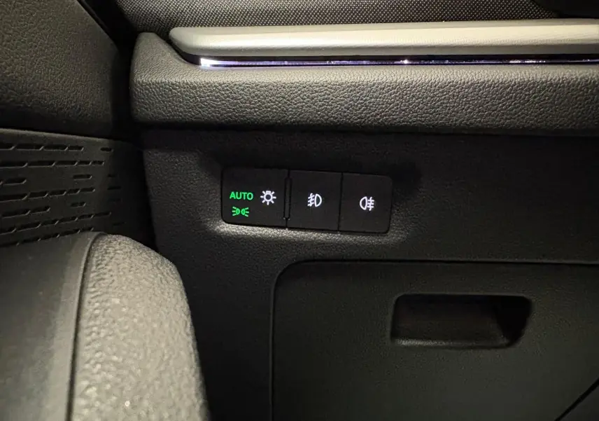 Détail des commandes d'éclairage avec mode automatique sur le tableau de bord d'une Skoda Octavia Combi gris argent 2023.