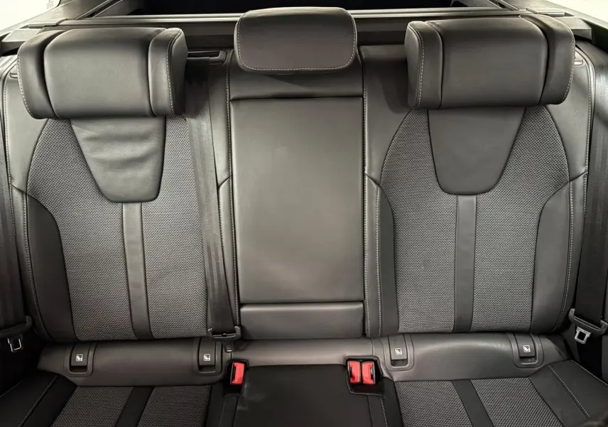 Vue rapprochée des sièges arrière en cuir noir et tissu gris de la Skoda Octavia Combi 2023.