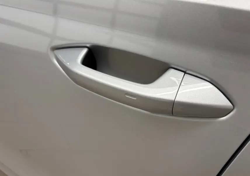 Poignée de porte côté gauche gris argent sur Skoda Octavia Combi 2023, finition Style diesel avec ouverture intégrée.