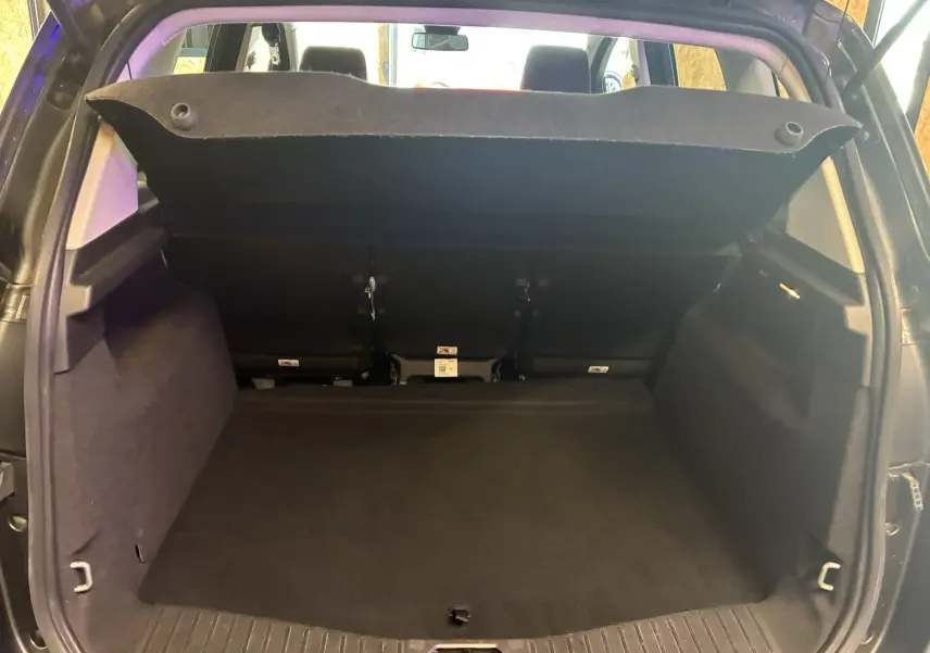 Coffre ouvert vu de l'arrière d'un Ford C-MAX gris 2015, montrant l'espace de chargement vide et la tablette arrière relevée.