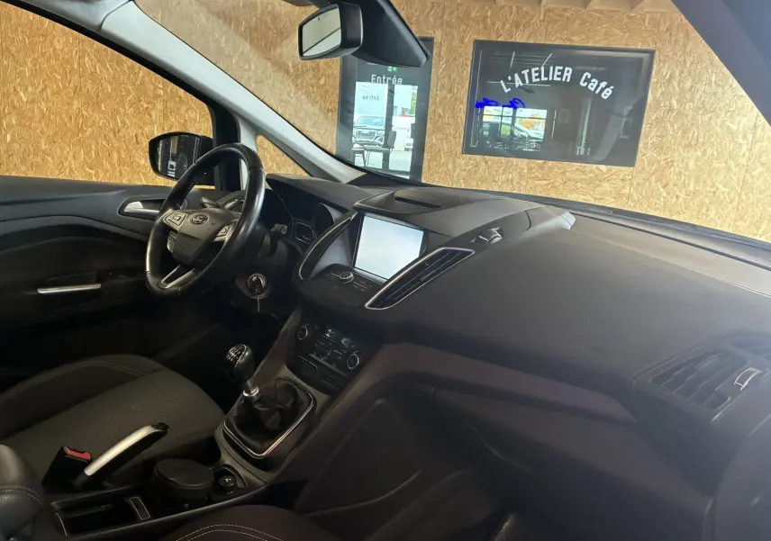 Intérieur avant droit du Ford C-MAX gris 2015, avec tableau de bord moderne, écran tactile et boîte manuelle visible.