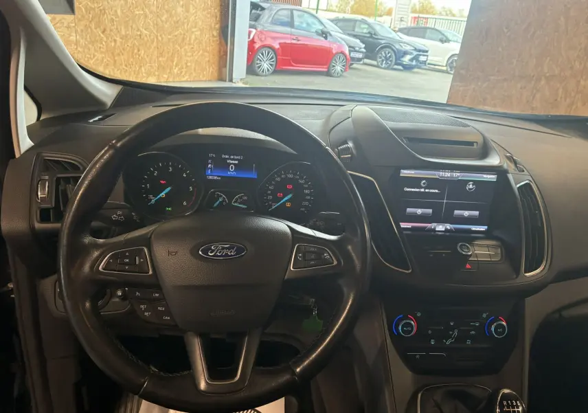 Vue intérieure avant du Ford C-MAX gris 2015, tableau de bord avec écran tactile et volant multifonction en cuir.