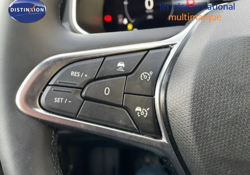 Gros plan sur les commandes au volant noir de la Renault Clio V 1.0 ECO-G 100CH TECHNO, soulignant les boutons de régulateur de vitesse.