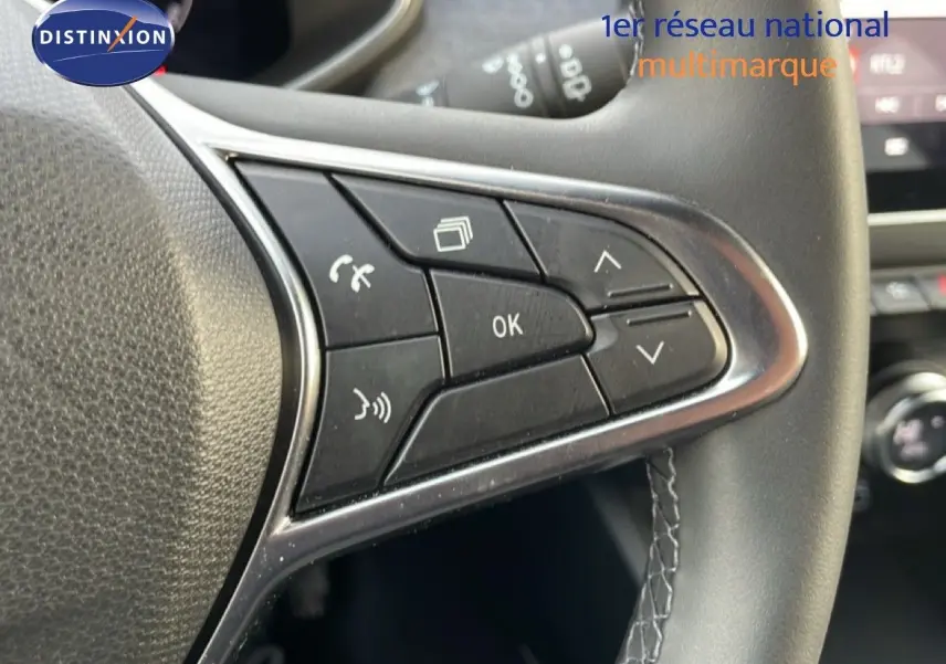 Gros plan sur les commandes multifonctions à droite du volant d’une Renault Clio 2025, cuir noir et finition chromée.